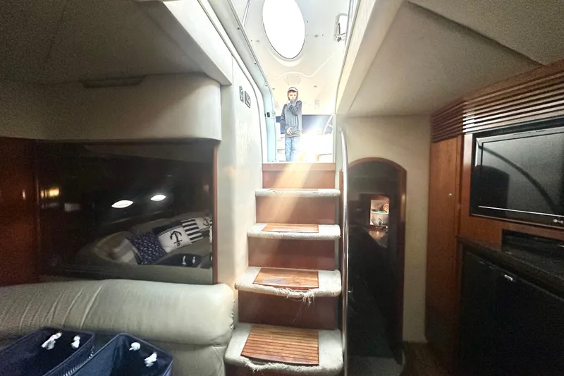 Slide: The Image of Interior of 2005 Cruisers Yachts 500 Express, featuring stairs and cozy cabin space. - 24