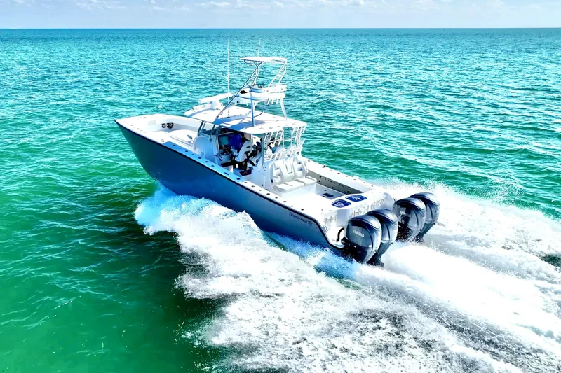 Slide: The Image of 2024 Freeman 42 boat on clear turquoise water, showcasing sleek design and powerful engines. - 1