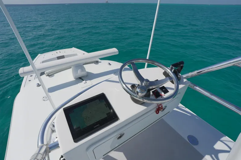 Slide: The Image of 2024 Freeman 42 boat helm with steering wheel and navigation screen on open sea. - 33