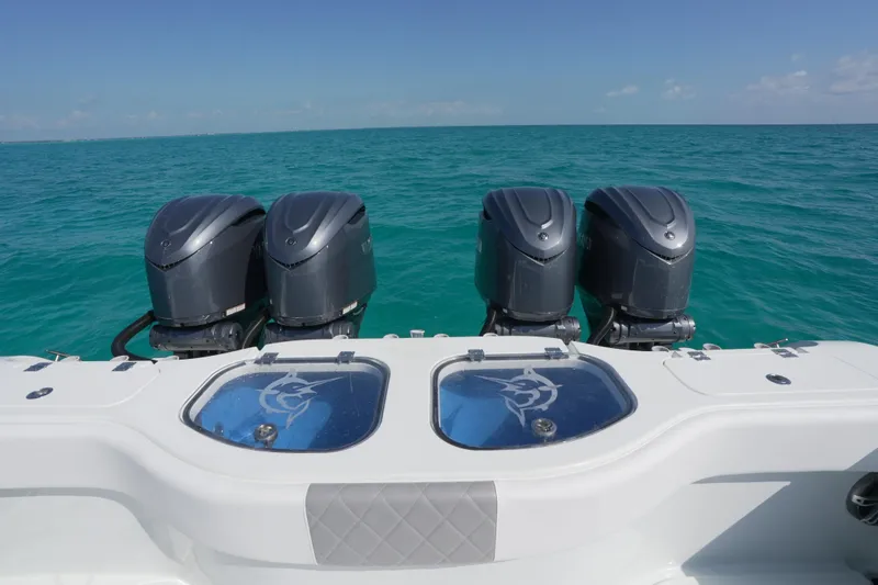 Slide: The Image of 2024 Freeman 42 boat with four powerful outboard motors on turquoise ocean water. - 34