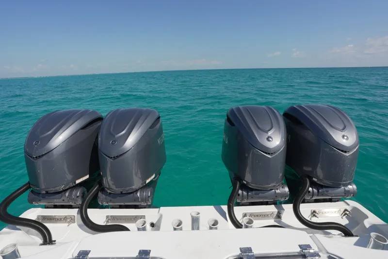 Slide: The Image of Four powerful outboard motors on a 2024 Freeman 42 boat, cruising in clear blue waters. - 35