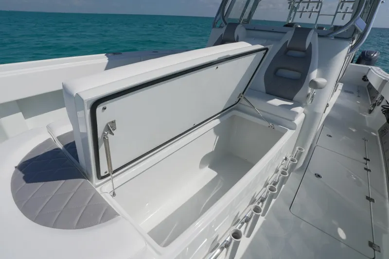 Slide: The Image of 2024 Freeman 42 boat interior with open storage compartment, sleek seating, and ocean backdrop. - 45