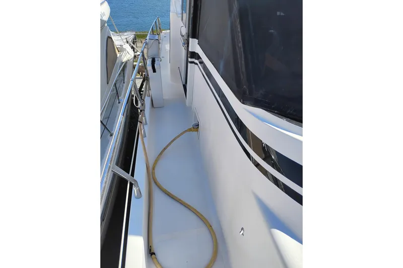 Slide: The Image of Side deck of a 1997 Symbol 50 Pilothouse yacht with railing and hose. - 11