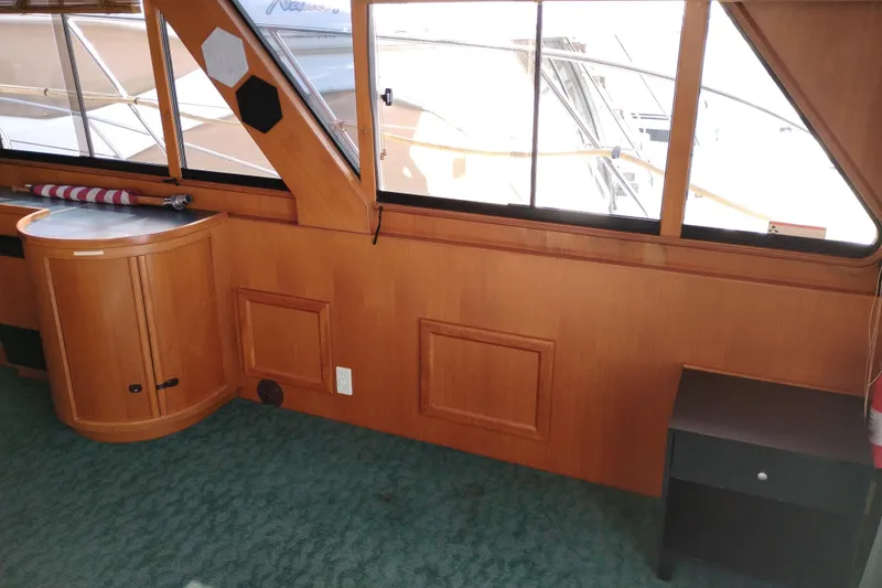 Slide: The Image of Interior of a 1997 Symbol 50 Pilothouse yacht with wooden paneling and green carpet. - 17