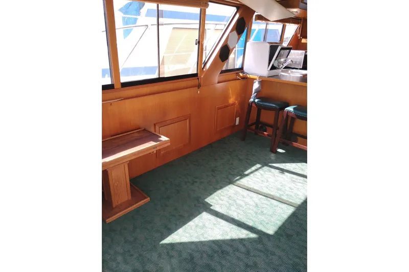 Slide: The Image of Interior of a 1997 Symbol 50 Pilothouse yacht with wooden paneling and green carpet. - 18