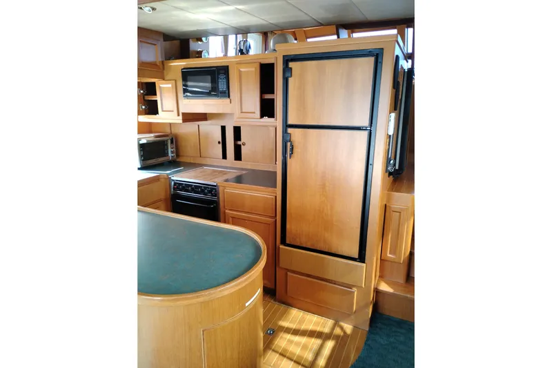 Slide: The Image of 1997 Symbol 50 Pilothouse yacht kitchen with wood cabinetry, appliances, and green countertop. - 20