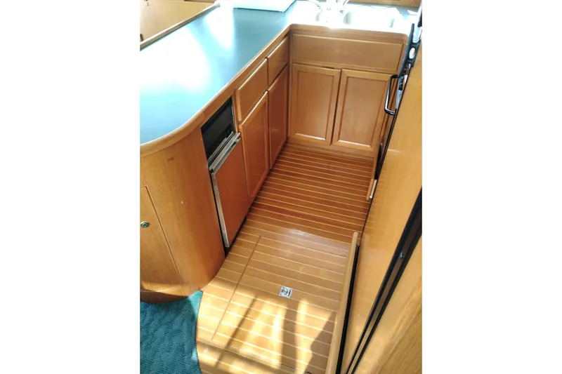 Slide: The Image of 1997 Symbol 50 Pilothouse yacht interior with wooden cabinetry and flooring. - 22