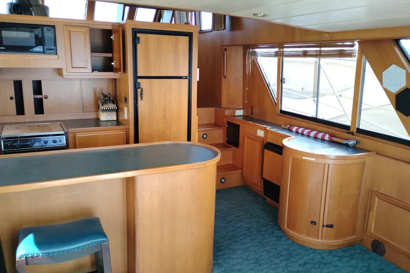 Slide: The Image of Interior of a 1997 Symbol 50 Pilothouse yacht with wooden cabinetry and modern appliances. - 28