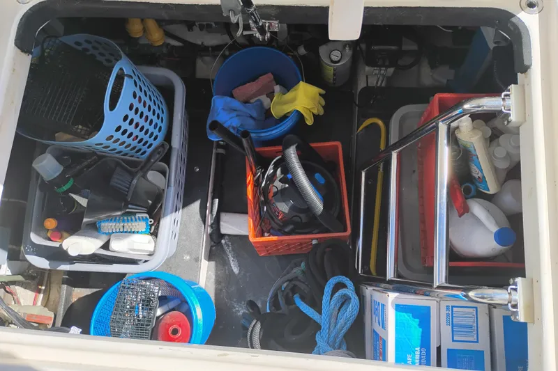 Slide: The Image of Storage compartment on a 1997 Symbol 50 Pilothouse, filled with cleaning supplies and tools. - 4