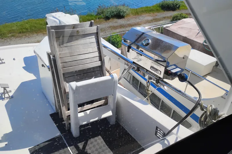 Slide: The Image of Outdoor deck of 1997 Symbol 50 Pilothouse with grill and stacked chairs. - 49