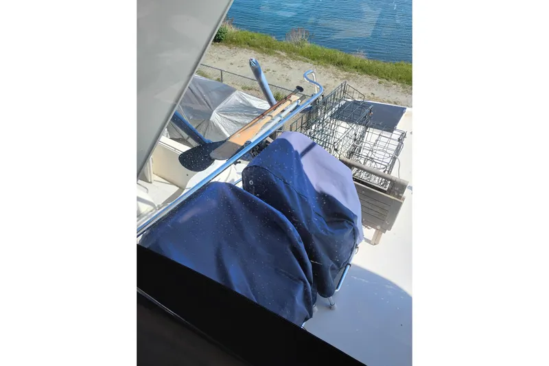 Slide: The Image of Covered equipment on a 1997 Symbol 50 Pilothouse boat deck near water. - 50