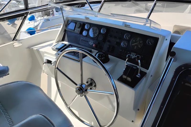 Slide: The Image of Steering wheel and control panel of a 1997 Symbol 50 Pilothouse yacht. - 52