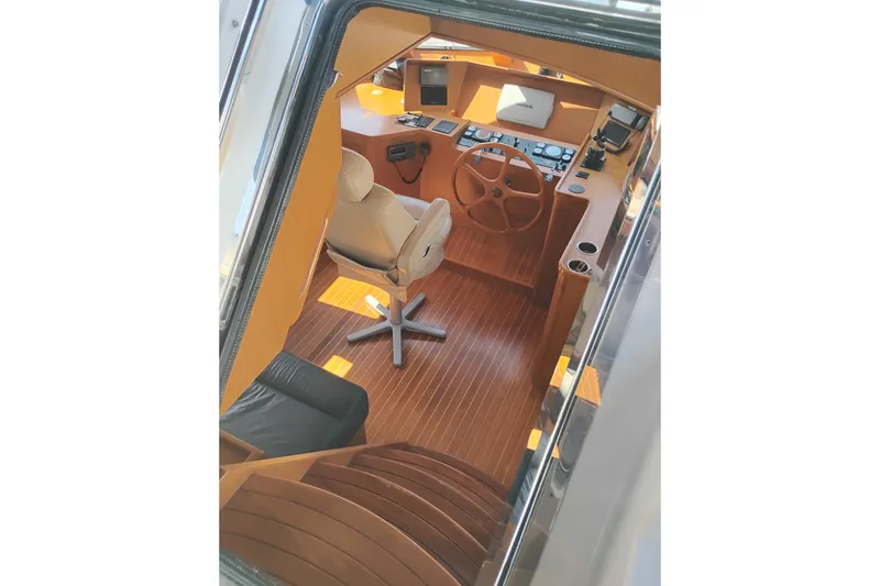 Slide: The Image of Pilothouse interior of 1997 Symbol 50, featuring wooden steering wheel and modern controls. - 56