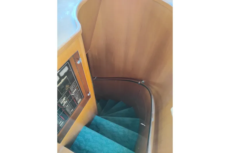 Slide: The Image of Curved wooden staircase with teal carpet in a 1997 Symbol 50 Pilothouse yacht. - 58