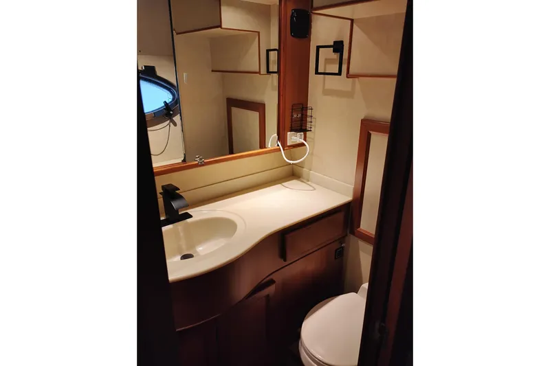 Slide: The Image of Bathroom interior of a 1997 Symbol 50 Pilothouse yacht, featuring sink and mirror. - 69