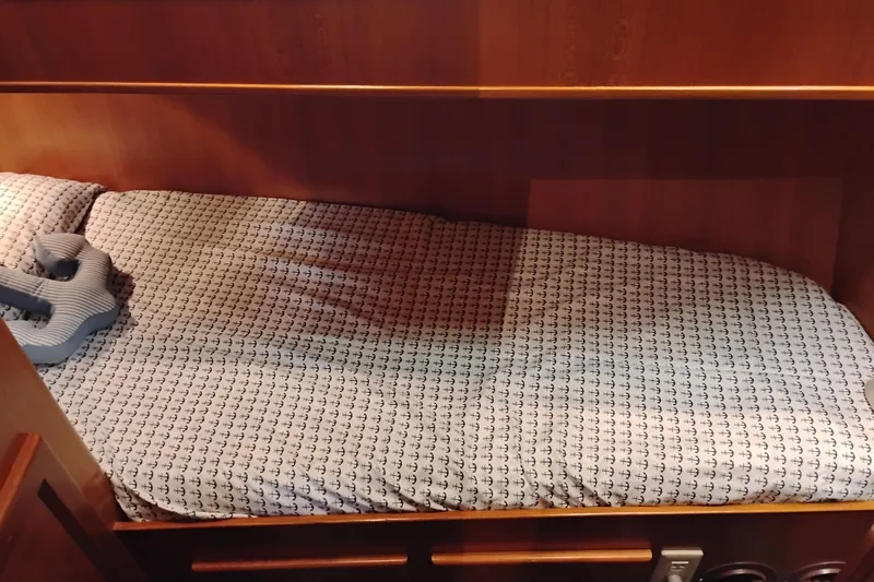 Slide: The Image of Cozy cabin bed with anchor-patterned bedding in a 1997 Symbol 50 Pilothouse yacht. - 73