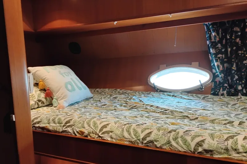 Slide: The Image of Cozy cabin bed in 1997 Symbol 50 Pilothouse yacht with porthole and decorative bedding. - 76