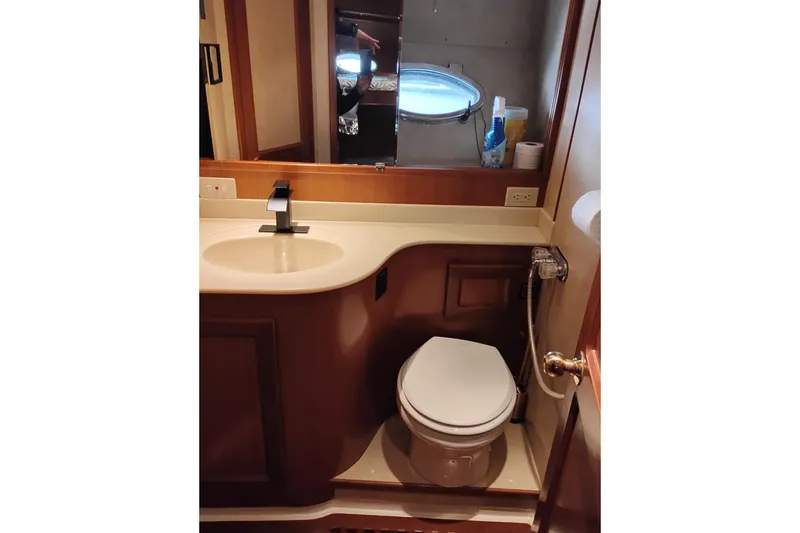 Slide: The Image of 1997 Symbol 50 Pilothouse bathroom with sink, toilet, and mirror. - 77