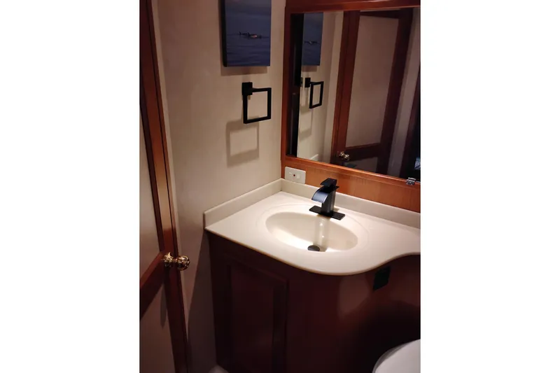 Slide: The Image of Bathroom vanity in a 1997 Symbol 50 Pilothouse yacht, featuring a modern sink and mirror. - 79