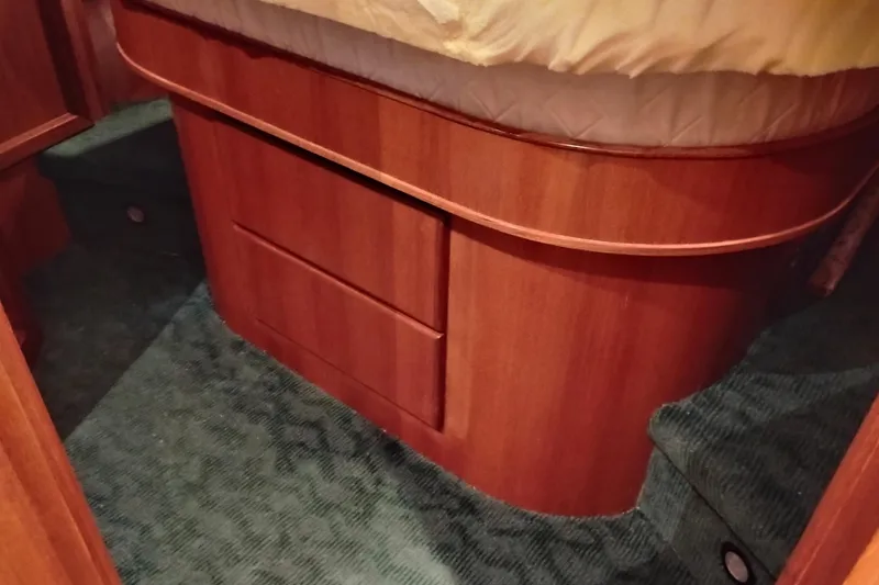 Slide: The Image of Interior of a 1997 Symbol 50 Pilothouse yacht with wooden cabinetry and carpeted flooring. - 83