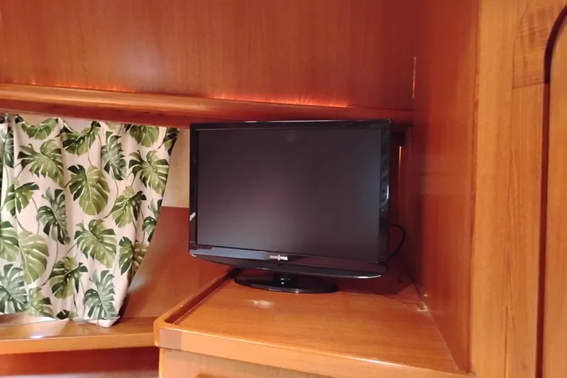Slide: The Image of Small TV in wooden interior of 1997 Symbol 50 Pilothouse boat, with leafy curtain. - 86