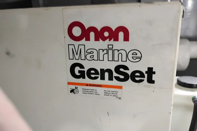 Slide: The Image of Onan Marine GenSet on Symbol 50 Pilothouse, 1997 model, with safety warning label. - 98