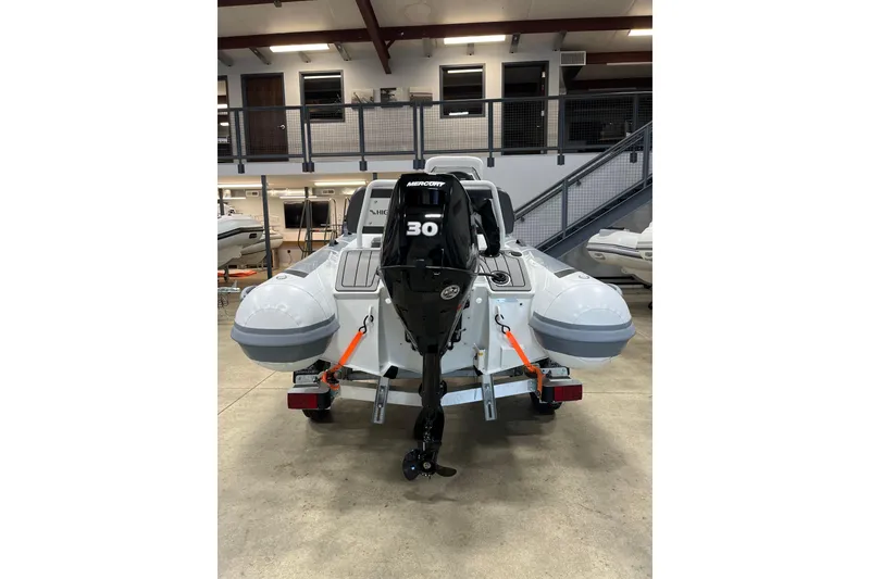 Slide: The Image of 2026 Highfield Sport 330 boat with Mercury 30 outboard motor in showroom. - 2