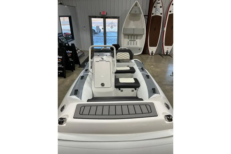 Slide: The Image of 2026 Highfield Sport 330 boat interior in showroom with paddleboards displayed. - 3