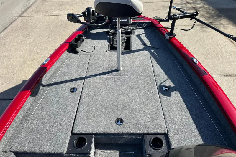 Slide: The Image of 2024 Tracker Pro Team 175 TXW boat with red exterior and gray carpeted deck. - 5