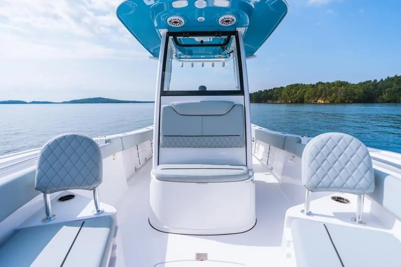Slide: The Image of 2026 Sportsman Heritage 231 Center Console boat on calm water, featuring sleek seating and modern design. - 27