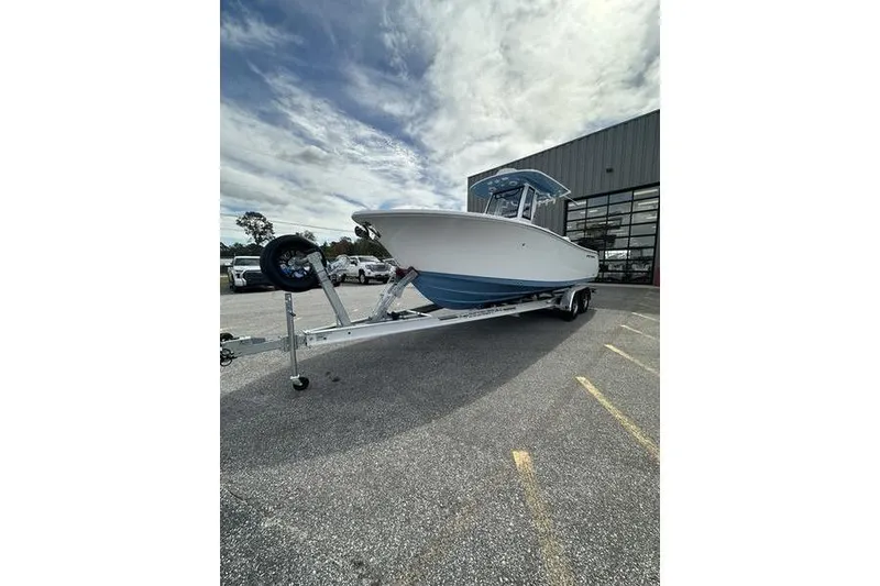 Slide: The Image of 2026 Sportsman Heritage 231 Center Console boat on trailer, parked outdoors. - 3
