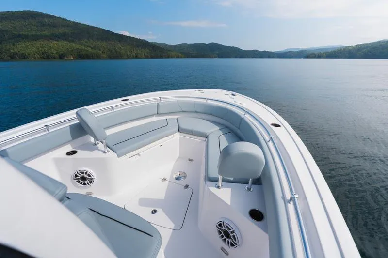 Slide: The Image of 2026 Sportsman Heritage 231 Center Console boat on serene lake with scenic mountain backdrop. - 31