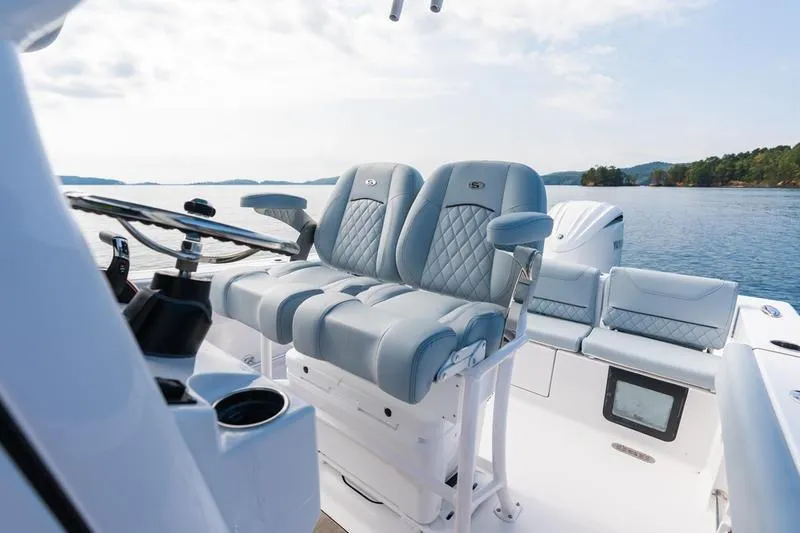 Slide: The Image of 2026 Sportsman Heritage 231 Center Console boat interior with luxurious seating on a serene lake. - 35
