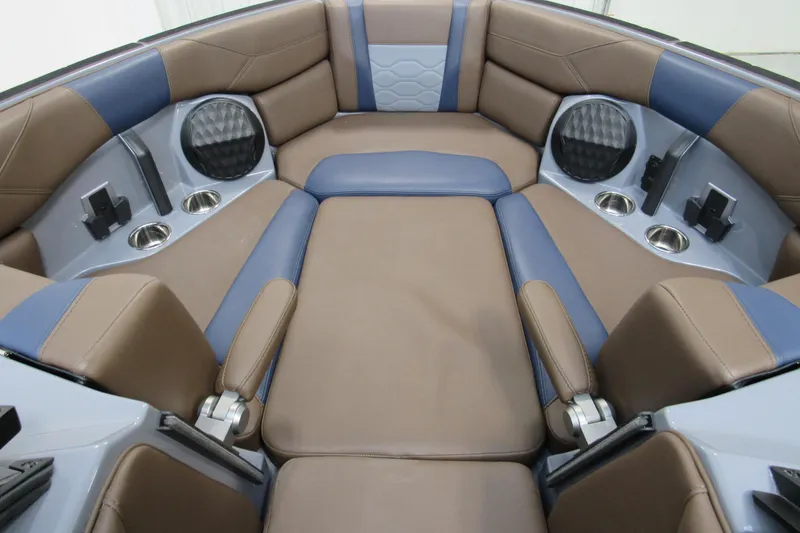 Slide: The Image of 2025 Malibu Wakesetter 23 LSV interior with brown and blue seating, cup holders, and speakers. - 4
