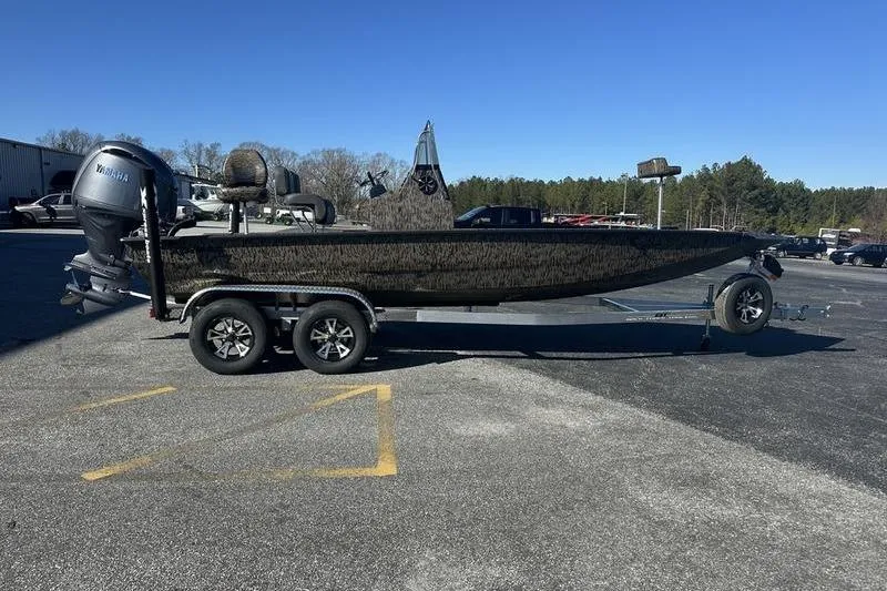 The Image of 2026 Xpress H210B Bay boat on trailer, parked outdoors under clear blue sky. - 0