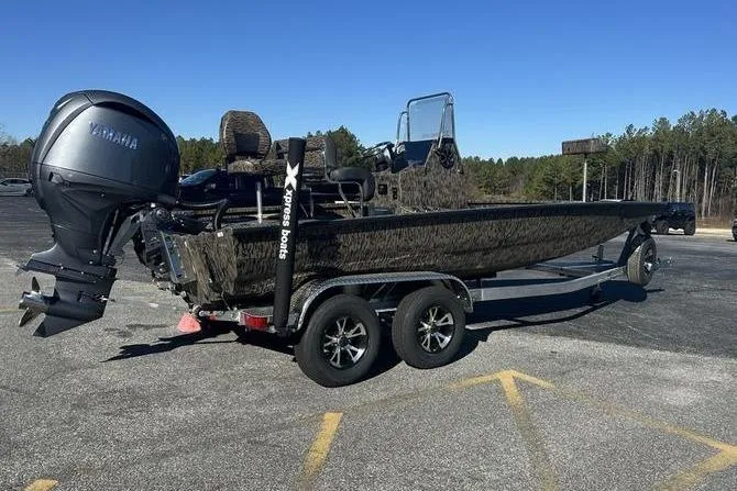 Slide: The Image of 2026 Xpress H210B Bay boat on trailer with Yamaha engine, parked outdoors. - 2