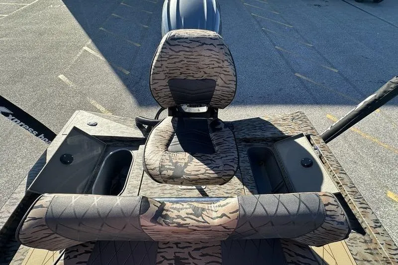 Slide: The Image of 2026 Xpress H210B Bay boat interior with camo seating and storage compartments. - 8