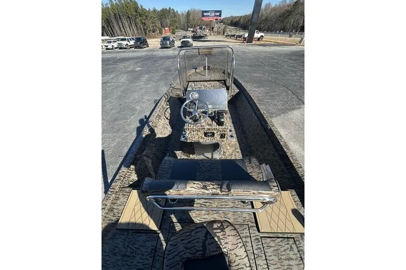 Slide: The Image of 2026 Xpress H210B Bay boat with camouflage design, parked outdoors. - 9