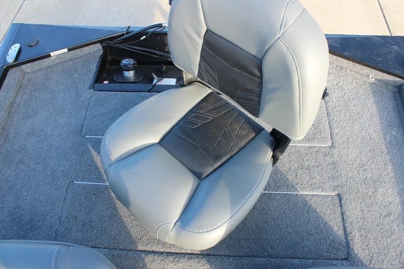 Slide: The Image of 2024 Tracker Pro 170 boat seat with gray and black upholstery on carpeted deck. - 16