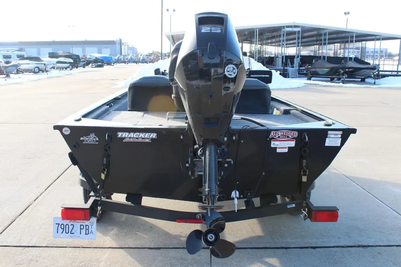 Slide: The Image of 2024 Tracker Pro 170 boat with outboard motor, parked on a trailer in a marina. - 6