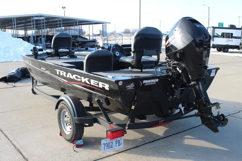 Slide: The Image of 2024 Tracker Pro 170 boat on trailer, parked outdoors, showcasing sleek design and powerful engine. - 7