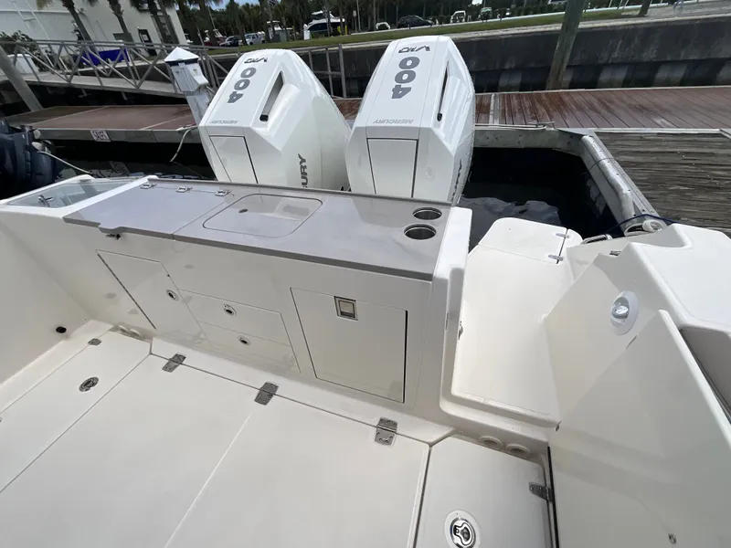 Slide: The Image of The image shows the stern of a Boston Whaler 330 Vantage with twin Mercury engines at a dock. - 13