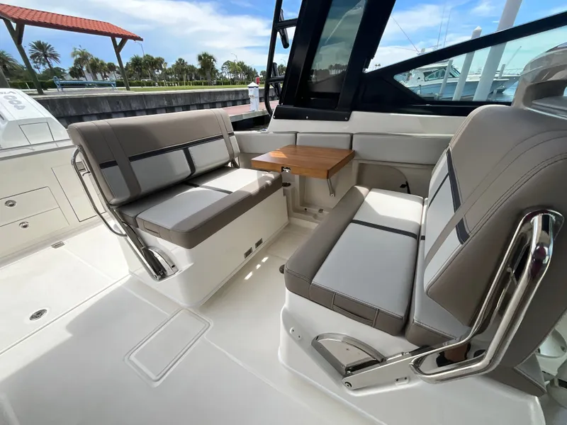 Slide: The Image of Interior of a Boston Whaler 330 Vantage with gray seating and a wooden table. - 19