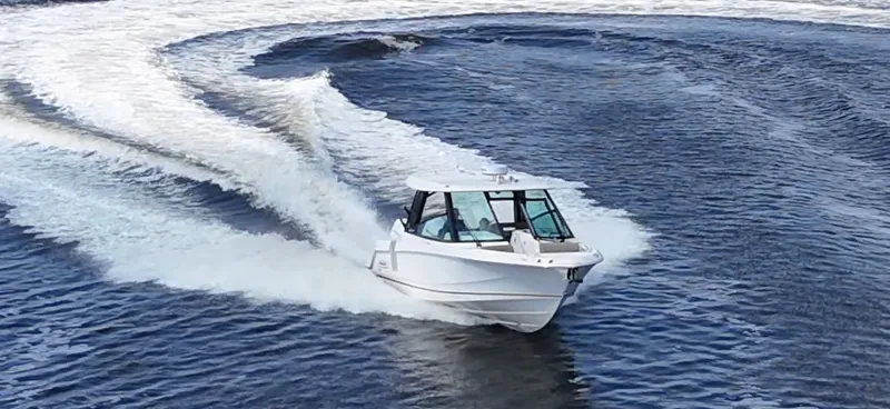Slide: The Image of A 2026 Boston Whaler 330 Vantage speeds across the water, leaving a white wake behind. - 9
