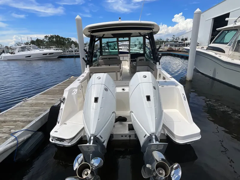 Slide: The Image of A 2026 Boston Whaler 330 Vantage is docked. It features twin outboard engines. - 12