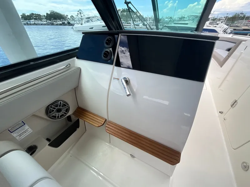 Slide: The Image of Interior view of a Boston Whaler 330 Vantage with wood accents and speaker. - 21