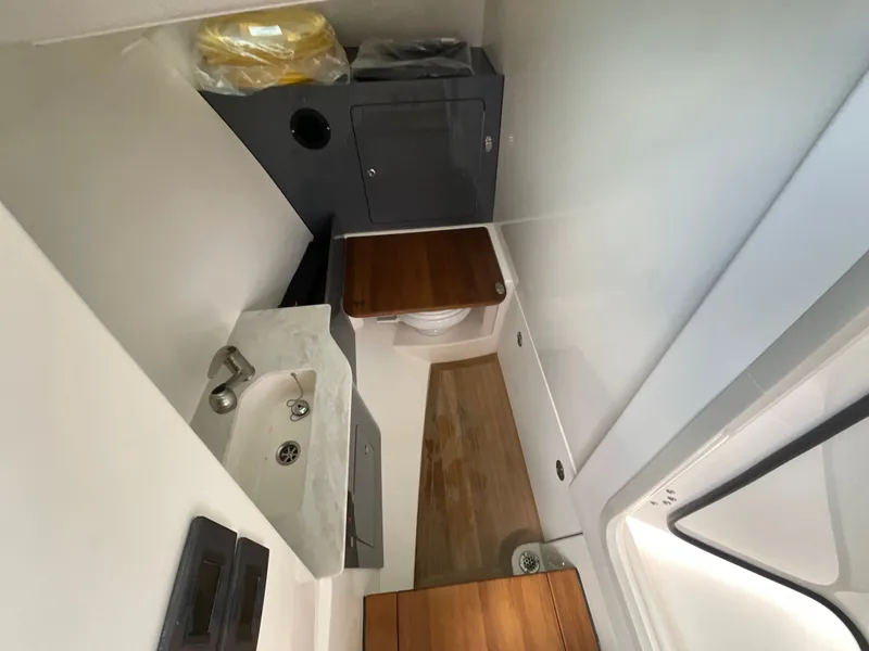 Slide: The Image of Interior of a modern boat cabin with a sink, toilet, and wood paneling. - 22