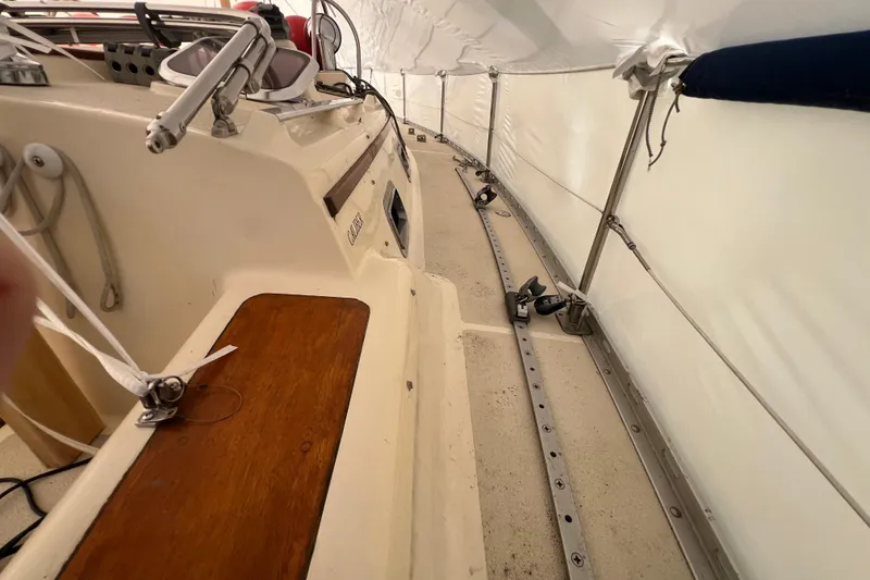 Slide: The Image of 1996 Caliber 35 LRC sailboat deck under protective cover, showcasing rigging and fittings. - 13