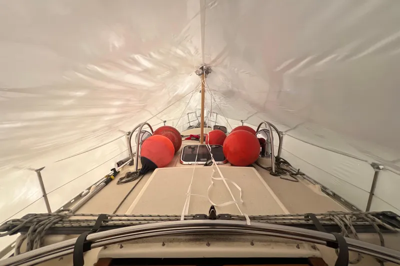 Slide: The Image of 1996 Caliber 35 LRC sailboat deck with red buoys under a protective cover. - 15