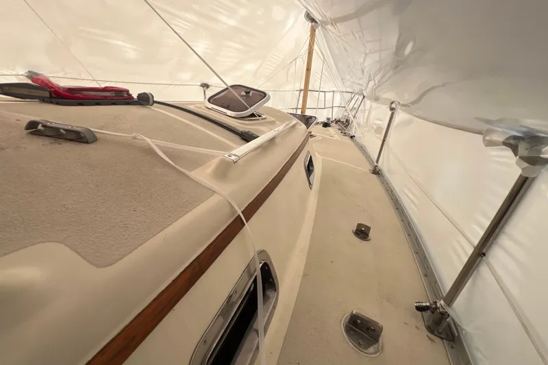 Slide: The Image of 1996 Caliber 35 LRC sailboat deck under protective cover, showcasing rigging and fittings. - 16